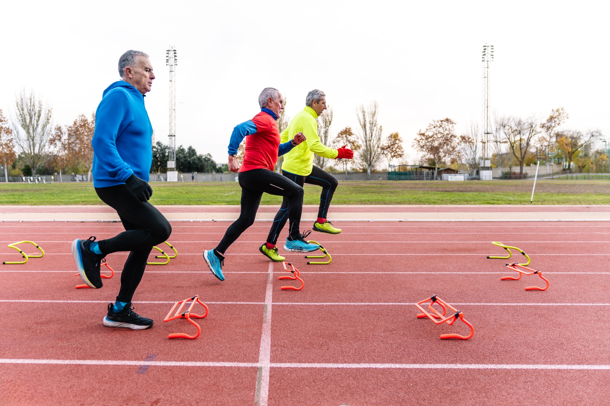 Active Senior Men Performing Agility Drills on Track