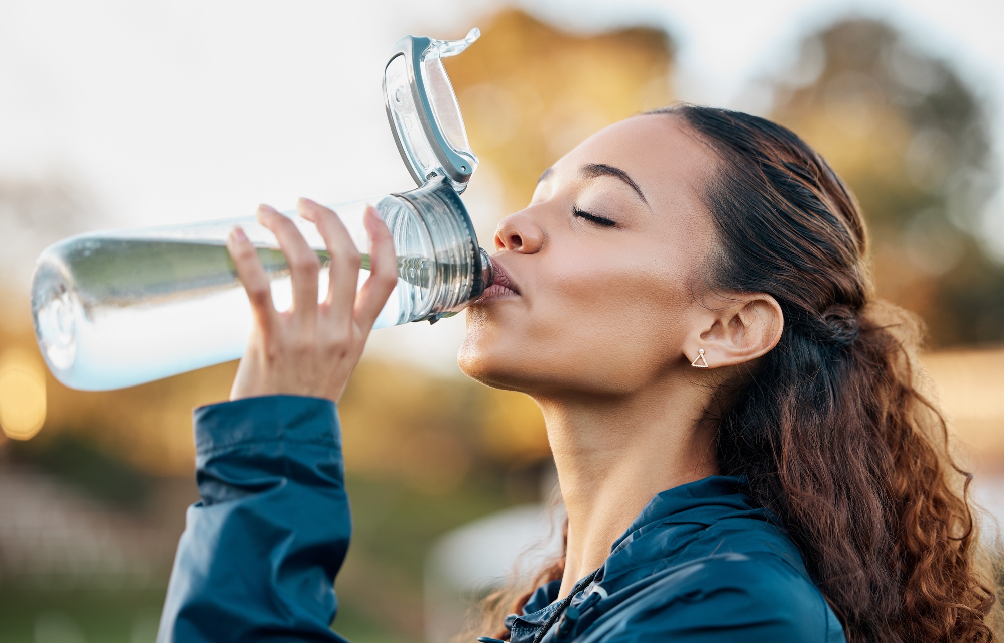 Outdoor, fitness and woman drinking water, health and workout with hydration, wellness and sports.